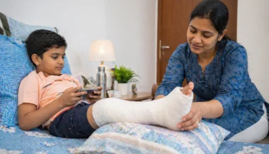 Parent caring for child after orthopedic surgery with cast and supportive care at home.