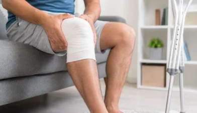 Orthopedic doctor examining patient's knee joint injury during consultation at clinic