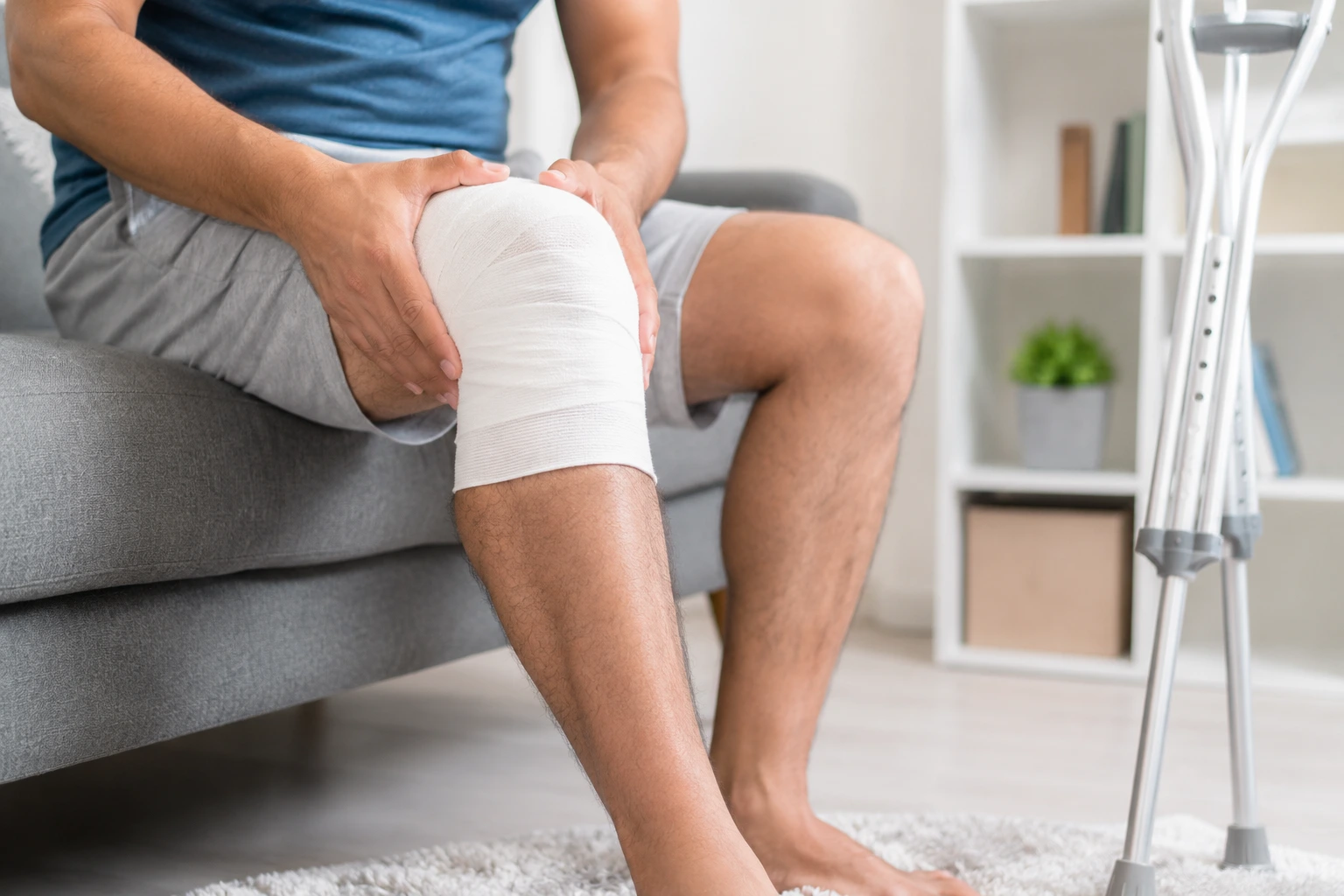 Orthopedic doctor examining patient's knee joint injury during consultation at clinic